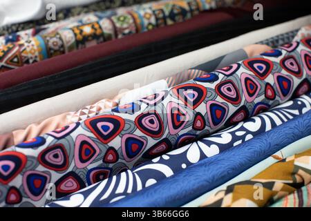 A Beautiful Array of Colorful Fabrics Rolled Up and Neatly Arranged in Stock Display Stock Photo