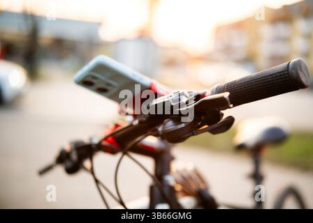 Smartphone On Bicycle Handlebar On City Street Stock Photo