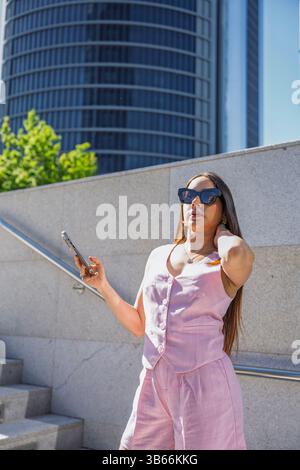 Businesswoman using mobile phone app for communication, browsing internet, checking social media, ordering taxi, shopping online Stock Photo
