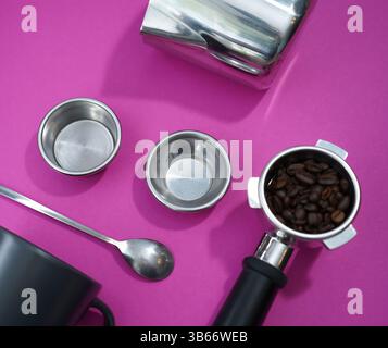 Portafilter, beans, and barista tools on vibrant pink background—perfect setup for espresso lovers and cafes. Stock Photo