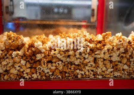 Caramel popcorn freshly cooked in glass street food ready for packing Stock Photo
