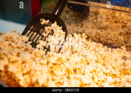 Popcorn scoop freshly cooked in glass street food ready for packing Stock Photo