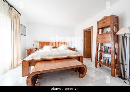 an image of a bedroom with wooden furniture in mediterranean home Stock Photo