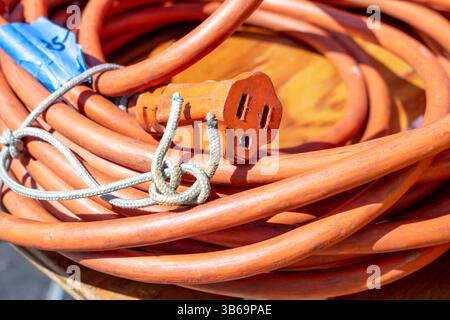 A closeup view of an orange electrical extension cord. Stock Photo