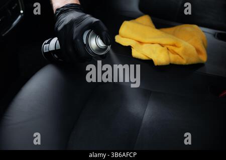 alcantara leather cleaning. spraying detergent foam on car seat Stock Photo