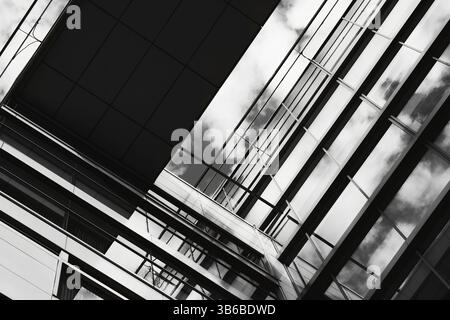 Black and white modern glass building viewed from below, abstract geometry and lines, strong contrast and light play Stock Photo