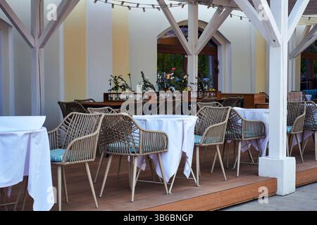 Empty tables with white tablecloths at a street restaurant Stock Photo