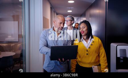 Business colleagues walking and talking in office corridor Stock Photo