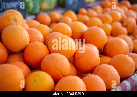 A table full of fresh navel oranges on display at a local farmers market. Stock Photo
