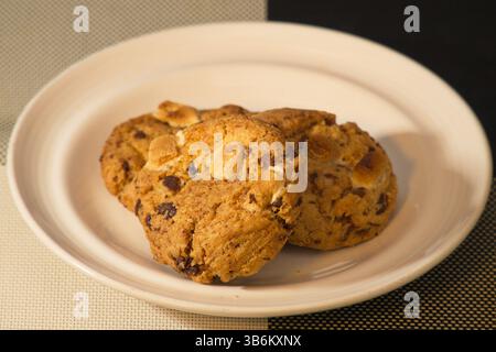 Close-up of chocolate chip cookies with marshmallows on a ceramic plate. Homemade dessert snack photography Stock Photo