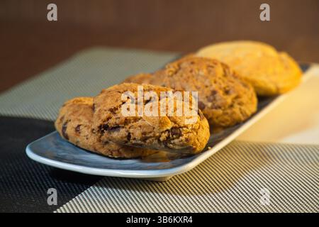 A delicious assortment of freshly baked cookies including chocolate chip, white chocolate, and butter cookies, beautifully arranged on a ceramic plate Stock Photo