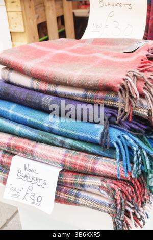 Warm traditional Scottish tartan tweeds for sale at an outdoor market stall Stock Photo