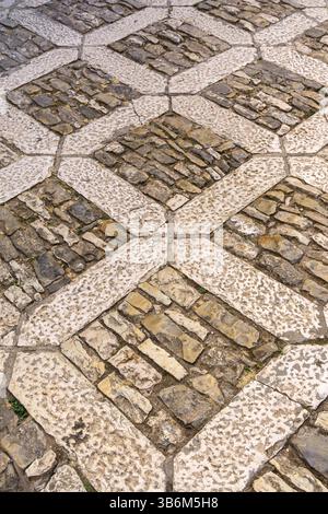 Intricate stonework forming a geometric design on a pathway, showcasing craftsmanship and creating visual interest Stock Photo