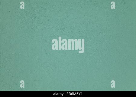 Green wall, texture, background. Decor of greenish textured coating. Structural plaster, rough, uneven surface in green, nephrite color. Green view Stock Photo