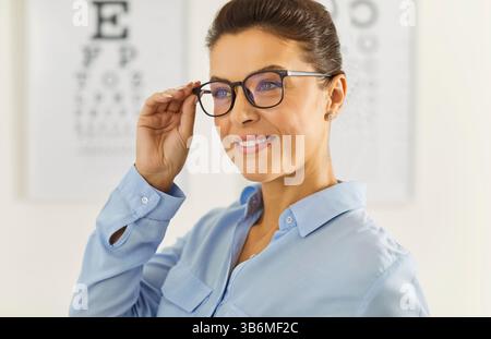 Close up portrait of young happy cheerful female patient standing in ophthalmology clinic Stock Photo