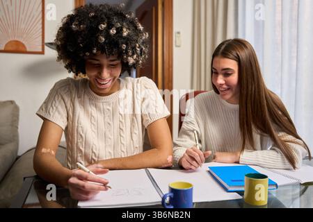 University students collaborating on project at home, sharing ideas and learning together Stock Photo