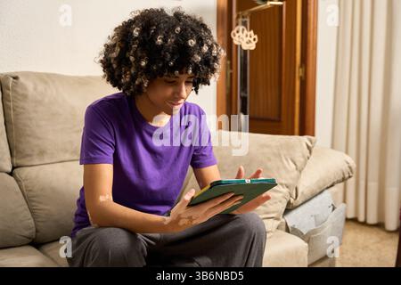 Young female student using digital tablet at home Stock Photo
