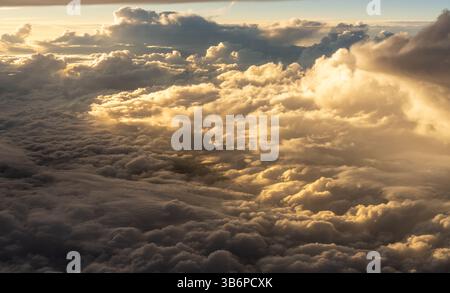 Golden clouds sky horizon in sunrise time, up in the air. viewed from an airplane window Stock Photo