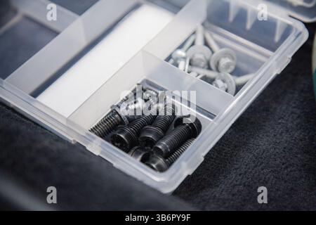 Background with car bolts and screws in a container Stock Photo