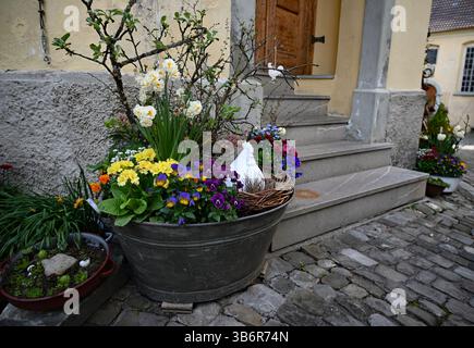 beautiful floral Easter decorations in an old tin vessel filled with spring flowers, branches and a porcelain hen Stock Photo