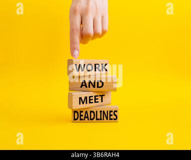 Work and deadline symbol. Concept words Work and meet deadlines on wooden blocks. Beautiful yellow background. Business and Work and meet deadlines co Stock Photo