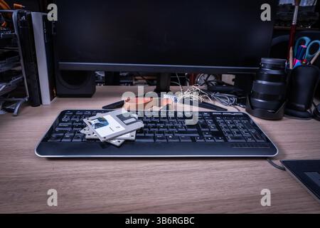 Vintage floppy disks resting beside contemporary keyboard, highlighting technological transition in professional workspace Stock Photo