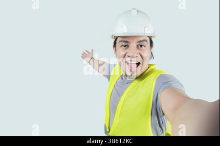 Selfie of smiling engineer inviting you isolated. Self portrait of happy construction engineer welcoming you Stock Photo