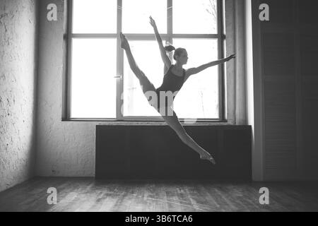 Plasticity slim woman dancing near window. Professional dancer enjoy dance. Lady Dancer Training Modern Ballet In Class. Contemporary dance performer. Stock Photo