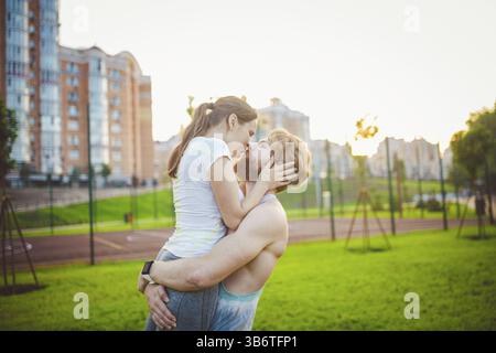Fit couple in city, having fun, taking break. Happy sport couple portrait while training in park. beautiful sporty couple smiling happy. Relaxing afte Stock Photo