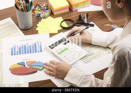 Close up of a female hand calculating, on the office desk Stock Photo