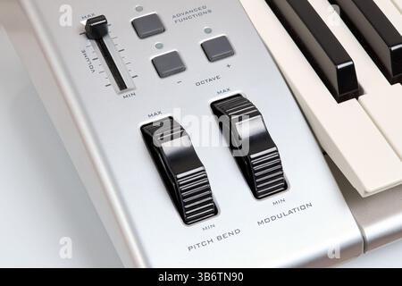 Midi keyboard controller close up with faders wheel buttons and knobs pitch, band, modulation, octave max min Stock Photo