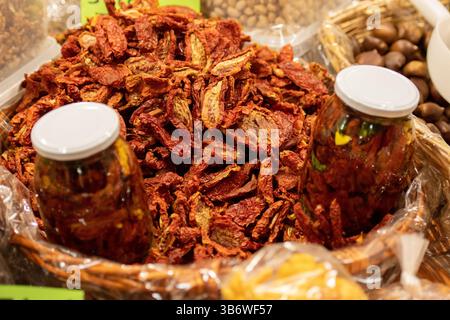 Fresh bio red ripe cherry tomatoes in a wicker basket with a glass jar  in a street food market, close up Stock Photo