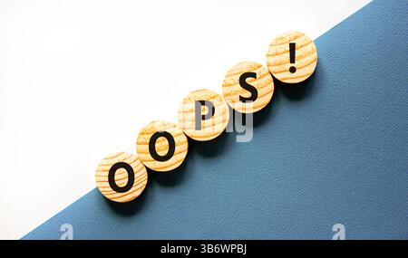 Oops symbol. Concept word Oops on beautiful wooden circles. Beautiful blue and white background. Business lifestyle oops concept. Copy space. Stock Photo