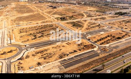 Aerial view of the "La Hoya" housing development, a major urban expansion project in Torrevieja, Spain. The site covers approximately 1.8 million square meters (1,830,000 m²) and plans for around 7,490 to 7,500 new homes (apartments, villas, bungalows). The area is bordered by the AP-7 motorway, the Quirón Hospital, and the protected Lagunas de La Mata y Torrevieja Natural Park. Developers involved include Duly Investment (Duly Promociones SL) and various real estate partners like Casas Espania and Medvilla Spanje. The project features modern architecture, green spaces, and community amenities Stock Photo