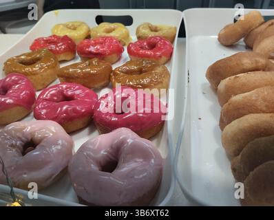 Close-up of colored glazed donuts. White and pink glazed sweet donuts. Stock Photo