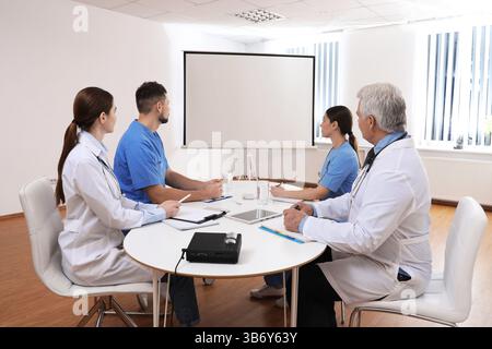 Team of doctors using video projector during conference indoors Stock Photo