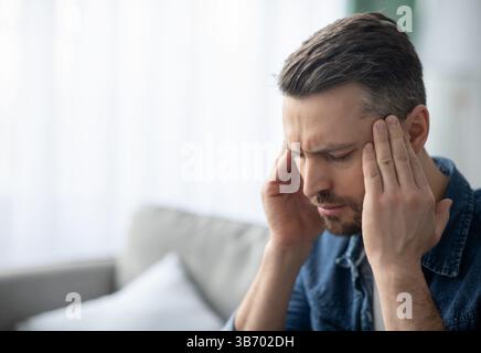 Closeup of middle-aged man suffering from headache Stock Photo