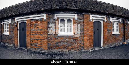 Curved brick cottage facade with two doors. Stock Photo