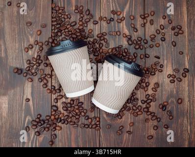 Aromatic roasted coffee beans with take-out mock-up paper cup. dark background, top view, copyspace. Stock Photo