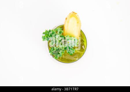 green vegetable juice with ice served in glass and garnished with fresh kale and ginger slice on white background. High quality photo Stock Photo