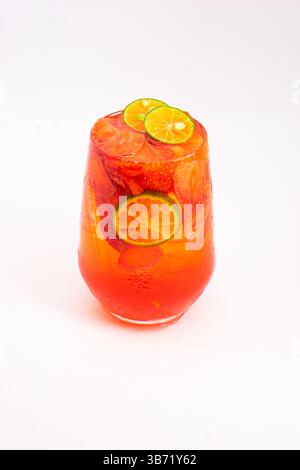 bright red fruit cocktail with sliced kumquats and ice served in transparent glass on clean white background. High quality photo Stock Photo