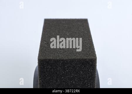 Texture of black tire shine foam applicator pad sponge close-up isolated on white background Stock Photo