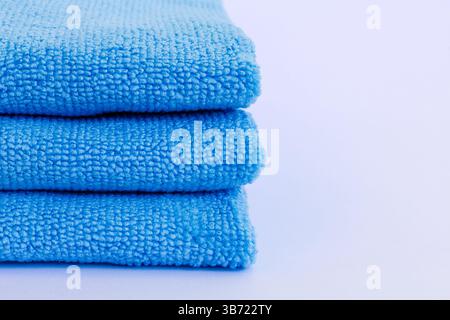 Edge of three blue low pile height microfiber towels stack isolated on white background Stock Photo
