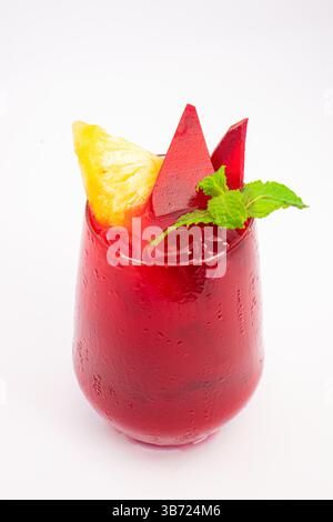 red beet or berry smoothie with pineapple slice and mint garnish served in transparent glass on white background. High quality photo Stock Photo