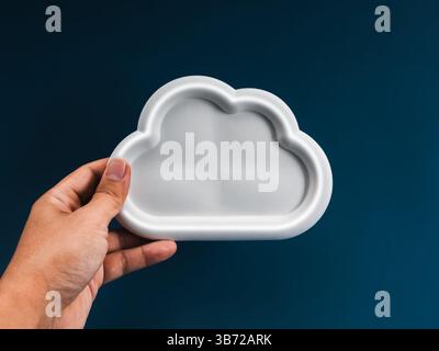 Cloud computing infrastructure technology, data system storage service concept. Empty white cloud with space, holding by businessman hand, on dark blu Stock Photo