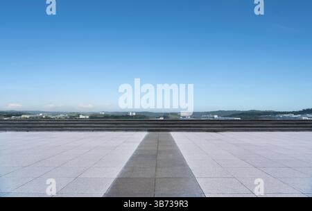 Empty square floor and city skyline with mountain view in background Stock Photo