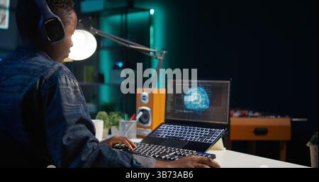 Data scientist using laptop, updating artificial intelligence machine learning algorithms, writing code scripts. Teleworking IT specialist in apartment office uses programming to upgrade AI, camera B Stock Photo