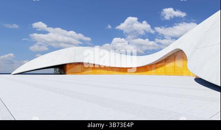 Futuristic building showcasing innovative architectural design with curved roofline and vibrant orange glass facade against a backdrop of blue sky and Stock Photo