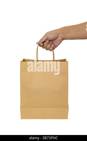 A hand holding brown paper bag against white background, showcasing simple and eco friendly packaging option. image highlights texture and design of b Stock Photo