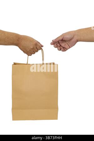 A two hands exchanging brown paper bag, symbolizing transaction or delivery. image captures moment of interaction, focusing on hands and bag against p Stock Photo